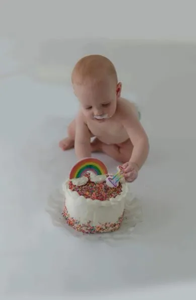 baby with rainbow cake