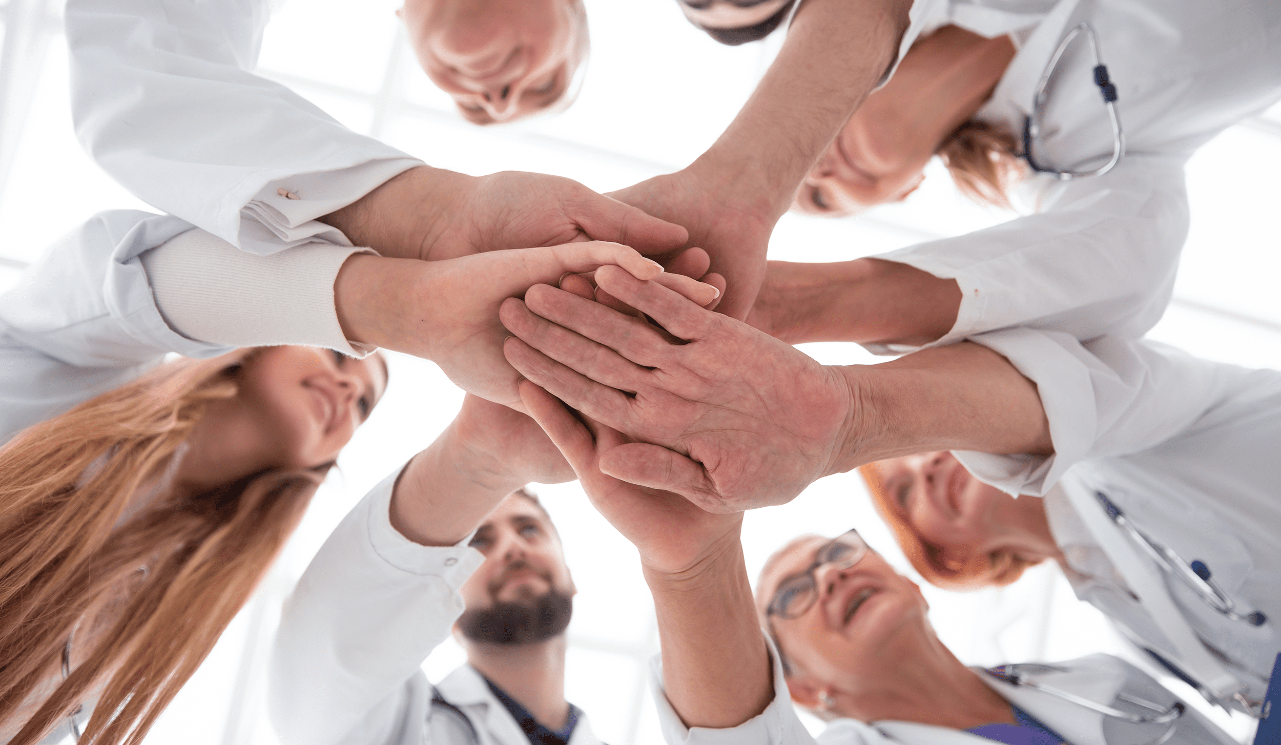 medical staff with hands together in a circle